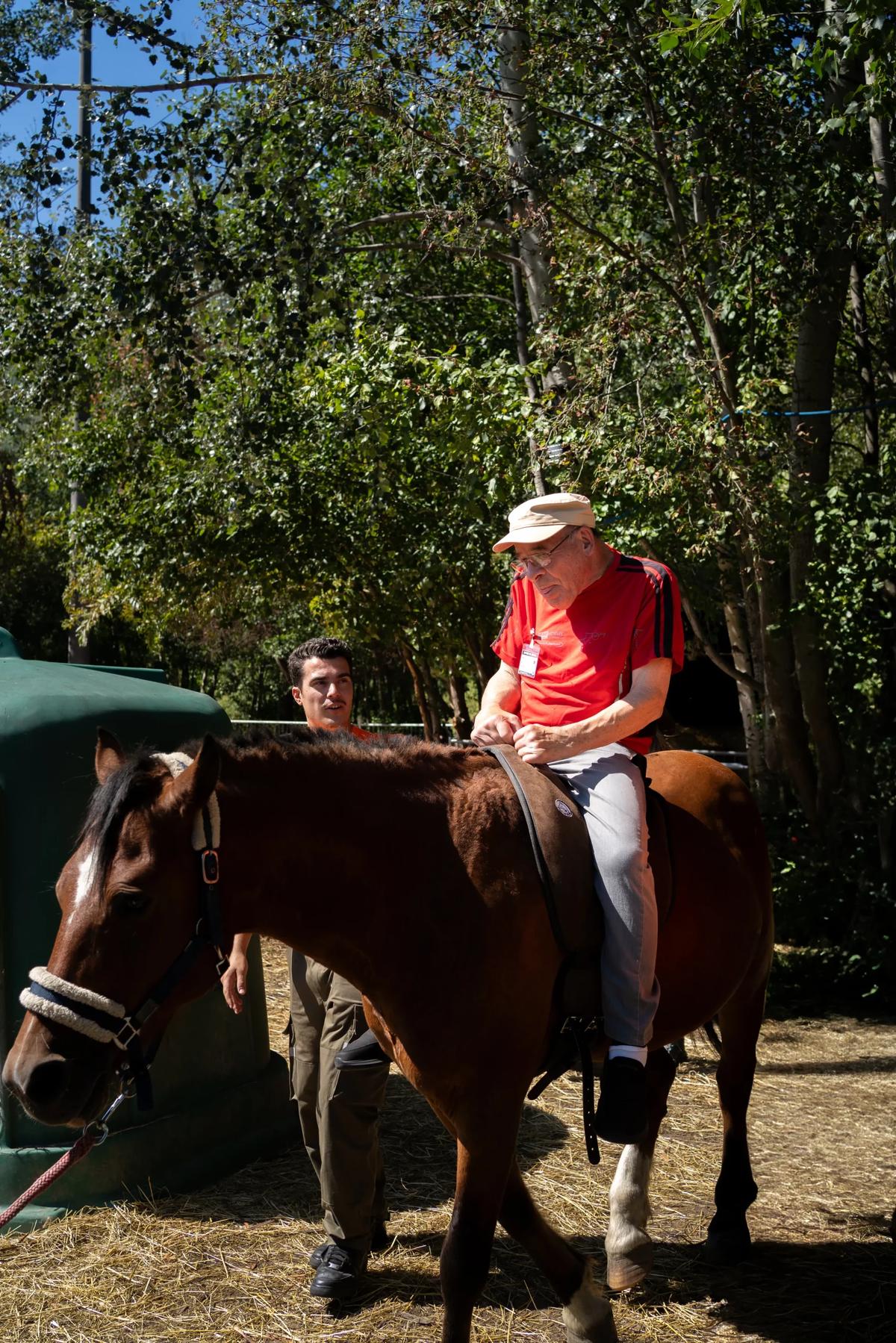 Un résident à cheval, accompagné par un bénévole, lors d'une sortie de l'édition 2025.